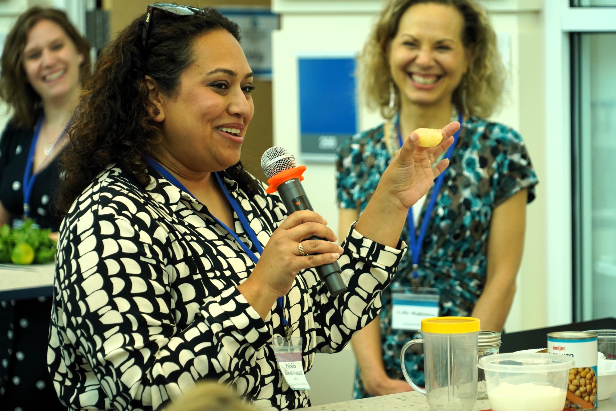 Woman smiling holding microphone and small snack